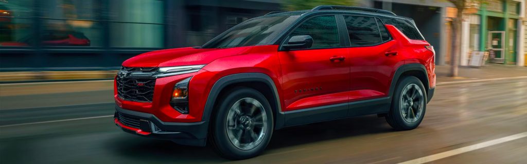 Red Chevrolet Equinox driving along a city street