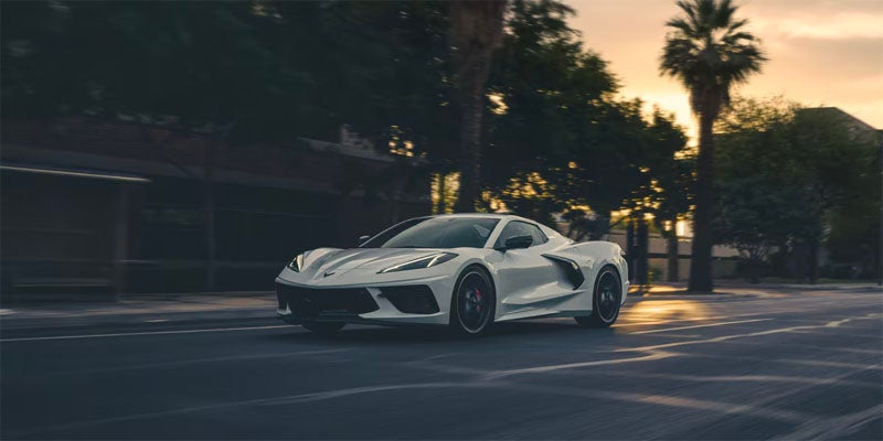 White Corvette driving at sunset