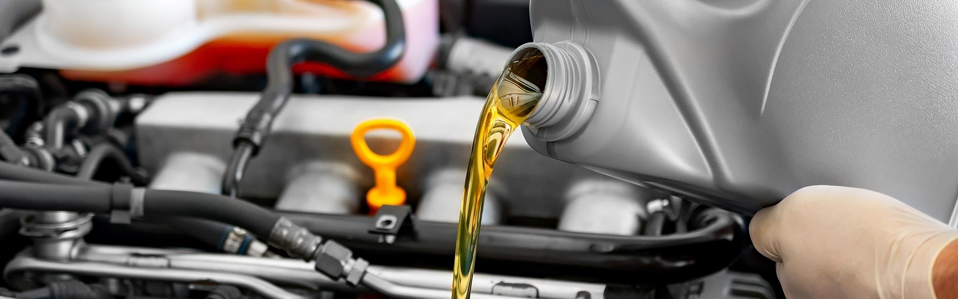 Fresh motor oil pouring into a car engine